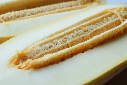 Close-up of a cut melon with seeds. Long ripe melon is cut in half lengthwise. Two melon halves with seeds