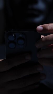 Phone scammers protection, mobile security, wearing black hood sitting in dark.