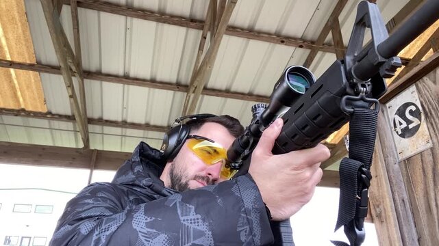 Man Aiming Rifle at Indoor Shooting Range in Texas