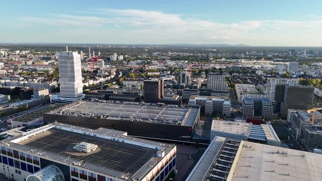 Aerial view of the Messe Frankfurt exhibition center with its modern architecture and large flat roofs overlooking the urban cityscape of Frankfurt am Main, Hessen, Germany.