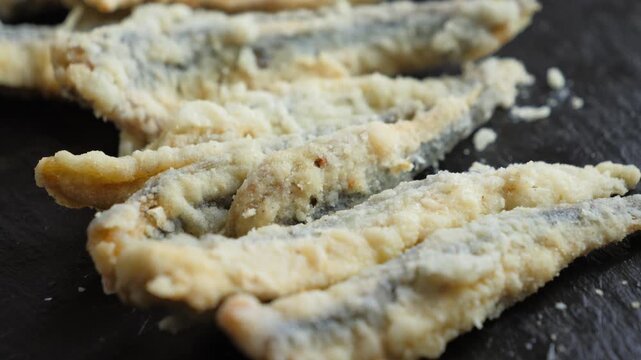 Close-up of fresh European anchovies, also known as boquerones, a popular small fish in Spain. Traditional Spanish tapas featuring fresh anchovies and Mediterranean seafood. High quality 4k footage