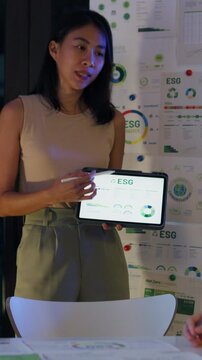 Vertical Screen : Group diverse Asia businesspeople talk ESG strategies risk management workshop night, SDGs, global warming, green finance and investment and net zero waste in boardroom building.