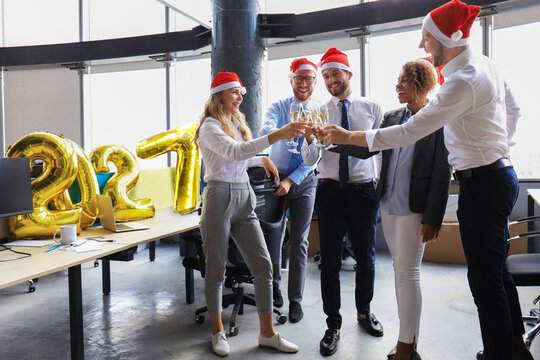 Business people are celebrating holiday in modern office drinking champagne and having fun in coworking. Merry Christmas and Happy New Year 2027