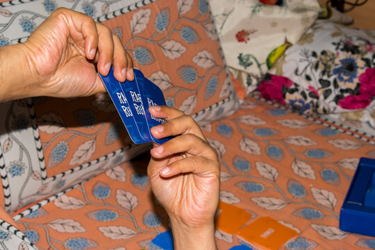man holding three letter cards of educational card game playing with family
