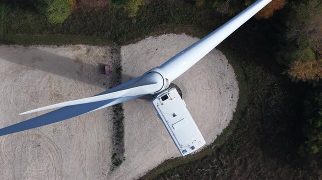 Aerial view of Parc eolien des trois cantons wind turbine with rotating blades above gravel ground Etouvans, Bourgogne-Franche-Comte, France.