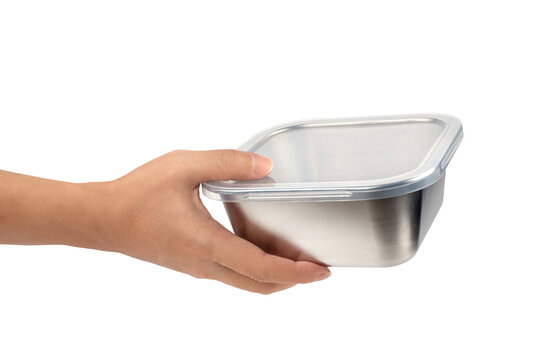 Hand holding stainless steel food container with clear plastic lid isolated on white background