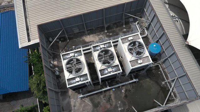 High-angle view of a cooling tower operating on a building rooftop.