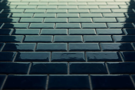 Glossy ceramic subway tile grid in deep navy and teal tones