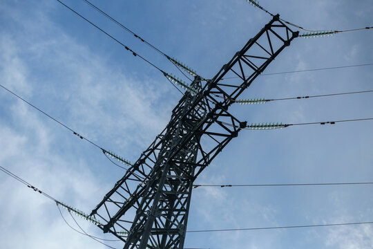 High voltage power transmission tower against blue sky