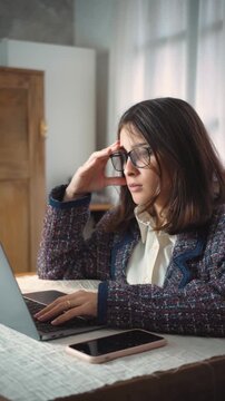 Young Hispanic secretary feeling tired and frustrated by problems with her laptop while working in the office. Concept of workplace stress, technical difficulties, professional pressure, computer prob