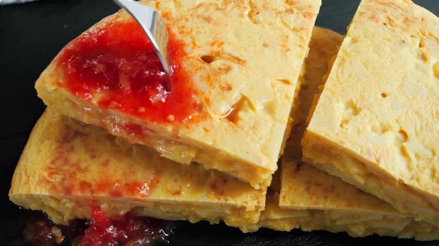 Traditional Spanish potato tortilla tortilla de patatas topped with grated Tomaquet de penjar hanging tomatoes, a traditional tomato variety used in Catalan cuisine. High quality 4k footage