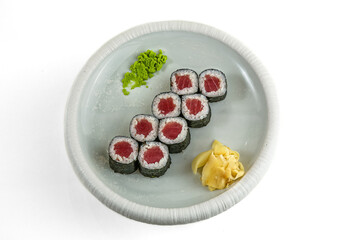 Tuna maki sushi rolls with wasabi and pickled ginger on white plate, top view, isolated on white background © Evghenii Blanaru