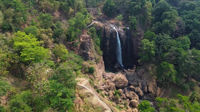 Aerial Drone Footage of Waterfall Flowing Through Lush Tropical Forest