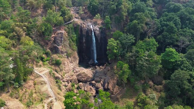 Aerial Drone Footage of Waterfall Flowing Through Lush Tropical Forest