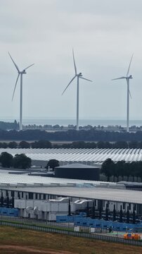 Aerial view of wind turbines and large industrial greenhouses at Agriport A7 in Middenmeer, Noord-Holland, Netherlands.