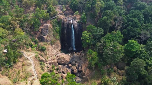 Aerial Drone Footage of Waterfall Flowing Through Lush Tropical Forest