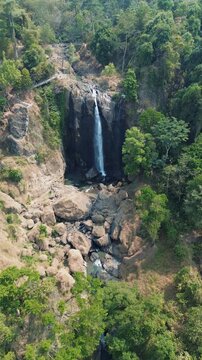 Aerial Drone Footage of Waterfall Flowing Through Lush Tropical Forest