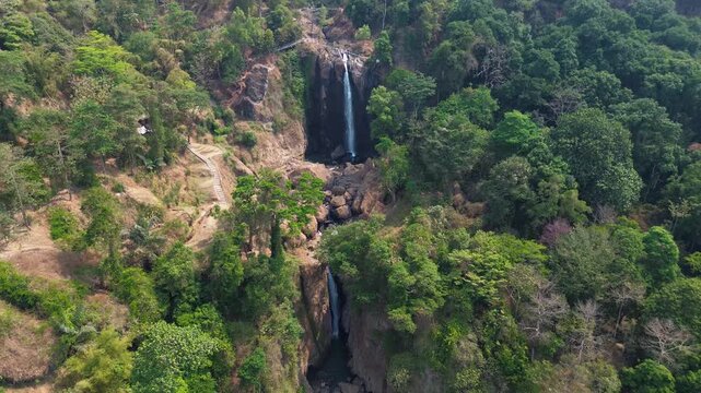 Aerial Drone Footage of Waterfall Flowing Through Lush Tropical Forest