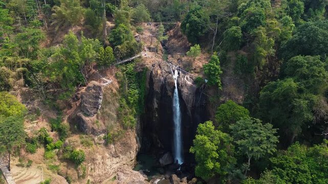 Aerial Drone Footage of Waterfall Flowing Through Lush Tropical Forest