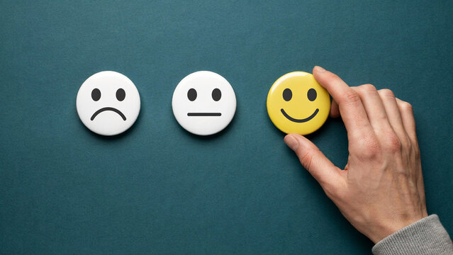 Hand choosing a happy smiley face button for customer service