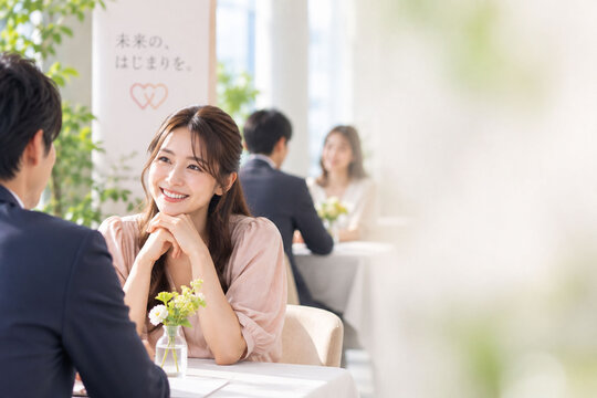 婚活パーティーで笑顔で会話する日本人女性