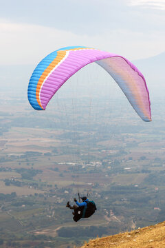 Parapendio in volo panoramico sopra una valle e colline   