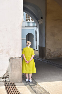 An Elderly Woman Stands in a Gateway in the Old Town of Vilnius, Lithuania