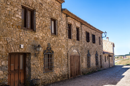 Tourism and rural life. A street in a traditional village featuring a long rustic stone fa&ccedil;ade,