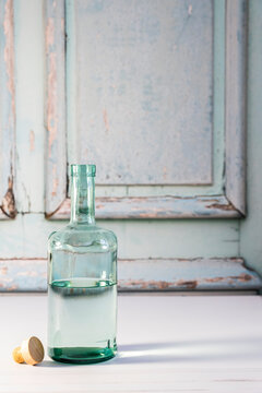 Bottle of open vodka against a weathered door backdrop 
