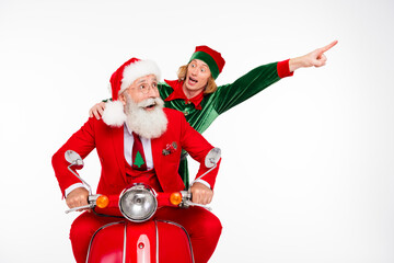 Fototapeta premium Santa Claus and excited elf riding a red scooter celebrating Christmas with festive outfits and joyful expressions