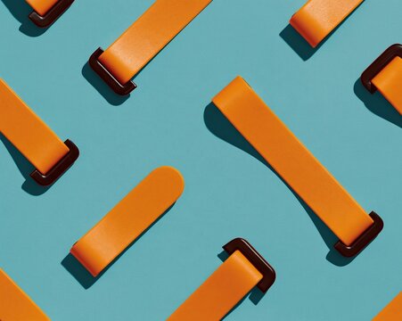 Yellow anti-tip furniture straps with black steel brackets arranged in a clean pattern on a sage background for earthquake safety and home security