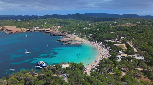Aerial view of the popular Cala Bassa beach strip bordered by calm sea and nature.