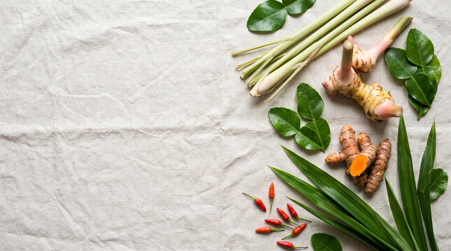 Fresh Thai tom yum ingredients lemongrass galangal and kaffir lime leaves on wooden table