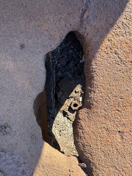 Broken stone wall revealing dark slag inside
