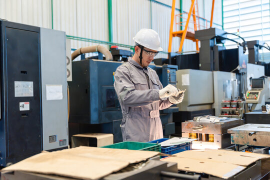 Technician measuring mold component precision with vernier caliper during plastic injection mold fitting and maintenance process inside industrial manufacturing factory