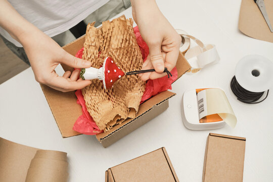 Handmade ceramic artist carefully protecting fragile product before shipment