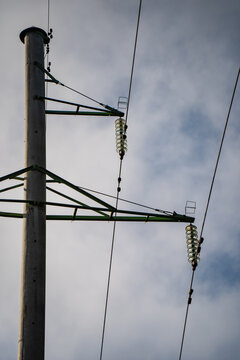 Overhead power line pole with glass suspension insulators, conductor clamps and reinforced crossarms, showing utility hardware for electrical isolation and conductor support