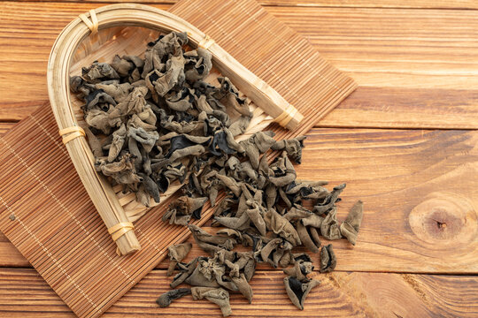 Dried Black Fungus Mushrooms in Bamboo Scoop on Wooden Table