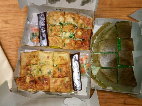 Top view of traditional Indonesian egg martabak and sweet martabak served in a box.