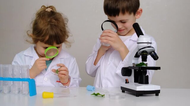 Laboratory examination of a child with test tubes, reagents and a microscope. Selective focus.