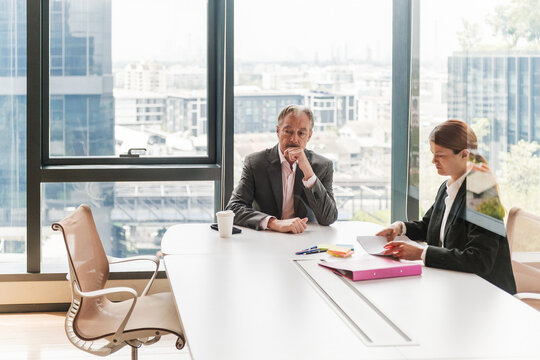 Senior Executive and Colleague Reviewing Documents in Modern Office