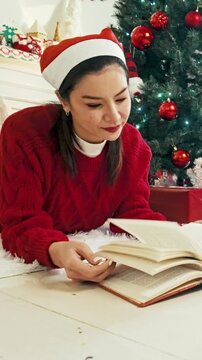 Woman Reading Book Beside Decorated Christmas Tree at Home