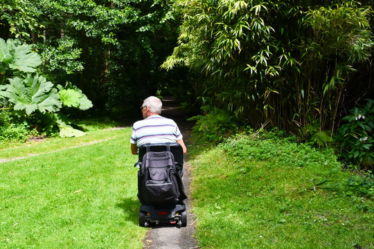 Male on a mobility scooter enjoying the independence it allows him to get out and about in the Shropshire  UK countryside , not letting his disability hold him back.