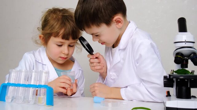 Laboratory examination of a child with test tubes, reagents and a microscope. Selective focus.