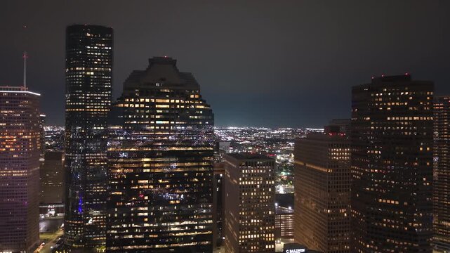 Aerial night view of Houston, Texas with dense commercial district and busy roadways. Modern illuminated buildings in city impressive skyline.