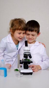 Laboratory examination of a child with test tubes, reagents and a microscope. Selective focus.
