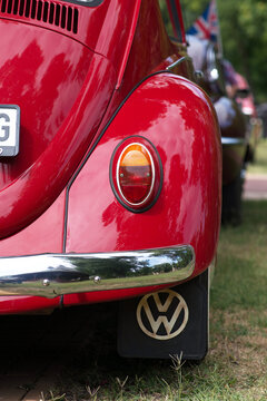 Red late 1960s classic Volkswagen Beetle Type 1 detail shot focusing on rear fender, oval tombstone tail light, chrome bumper, mud flap and oval YU country badge.  Palic, Serbia, Jul 5, 2026