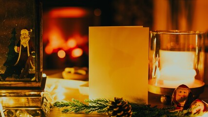 Cozy holiday scene with candles, pinecones, and a blank card by a fireplace. © Rawpixel.com