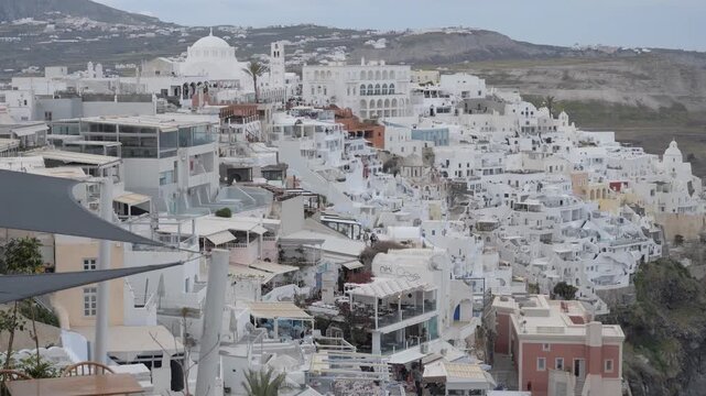 Fira, capital of Santorini in the Cyclades islands, with the Orthodox Metropolitan Cathedral dome above cliffside hotels and terraces along the caldera rim