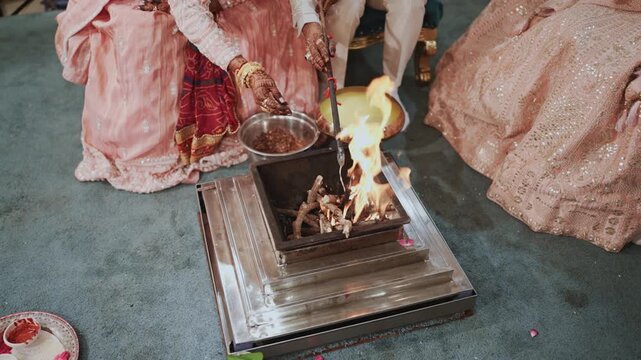 Indian Wedding Mandap Ritual Offering Havan Samagri and Ghee into Holy Fire